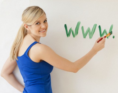 USA, New Jersey, Jersey City, Blonde young woman writing web address on wall